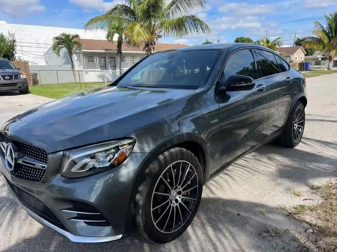 A grey Mercedes-Benz with a luxury interior parked outside a guest house.
