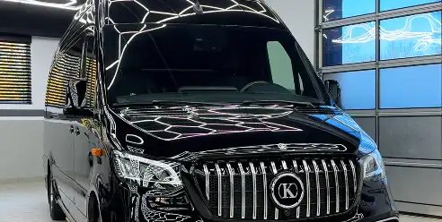 A black luxury Mercedes Sprinter van parked and ready for premium transport service.
