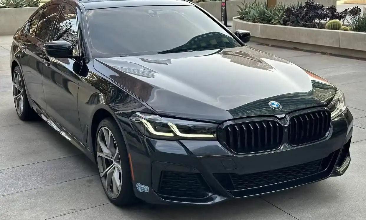 A black executive BMW i7 parked on the side of a road.