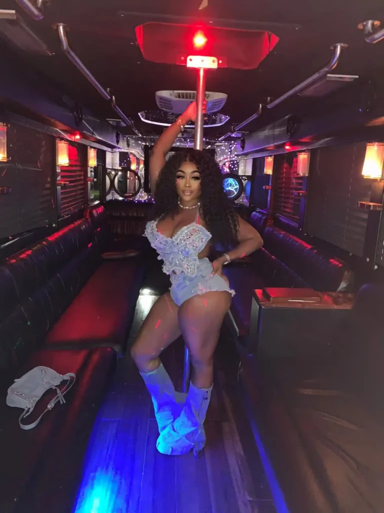 Black girl posing inside a luxury party bus miami, standing confidently and enjoying the vibrant party atmosphere.
