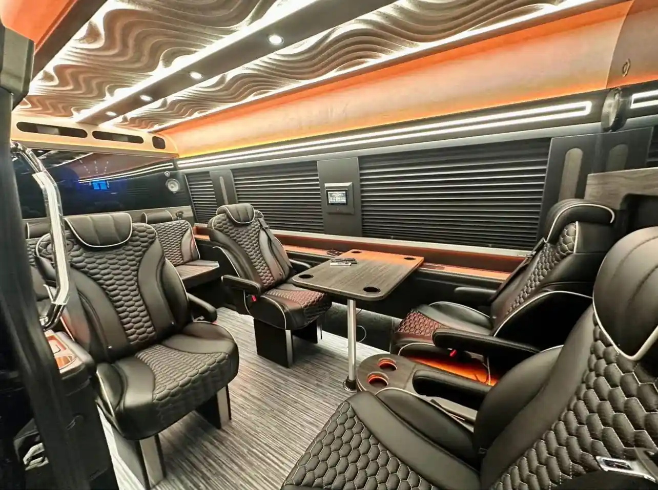 Luxury party bus miami interior with sofa seats and ambient lighting, creating a cozy and stylish party atmosphere inside.
