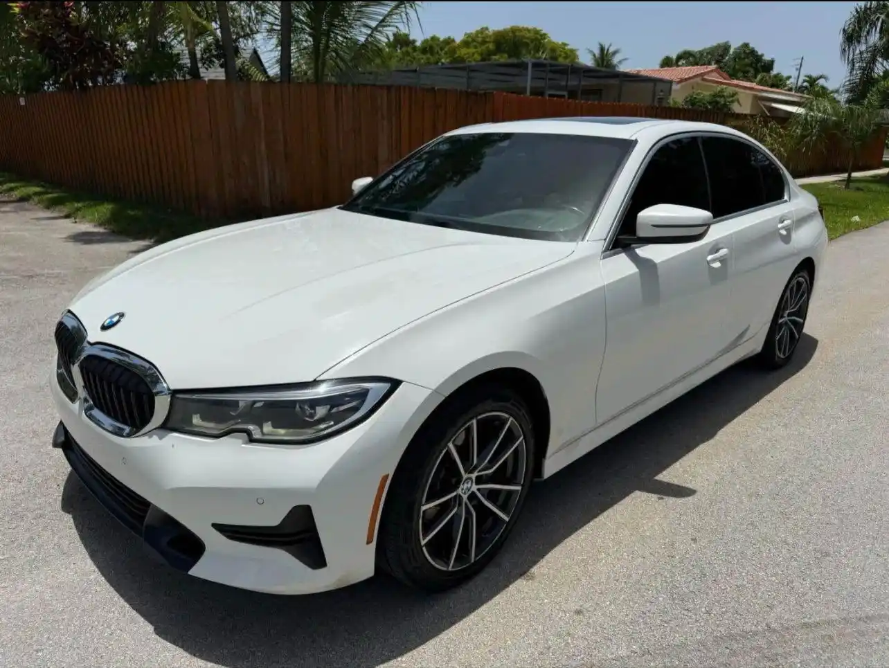 White BMW new model from Car services Miami, part of our premium chauffeur luxury fleet, parked outside on a sunny day.