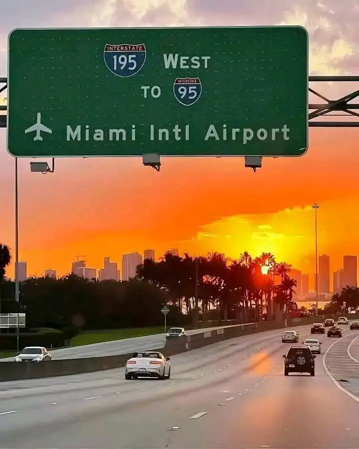 Motorway leading to MIA airport with overhead highway sign directing drivers to Miami International Airport.